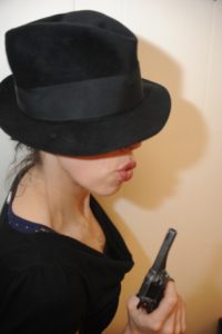 Holly holding a pistol for a mystery dinner