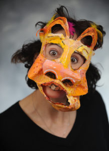 Holly wearing a large animal mask made from manila folders