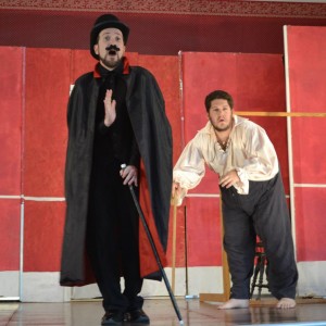 Two performers on stage with comedic expressions