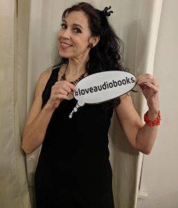 Holly holding a "loveaudiobooks" sign on her way to an event