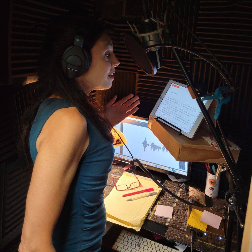 Holly Adams runs a vocal warm up in her booth