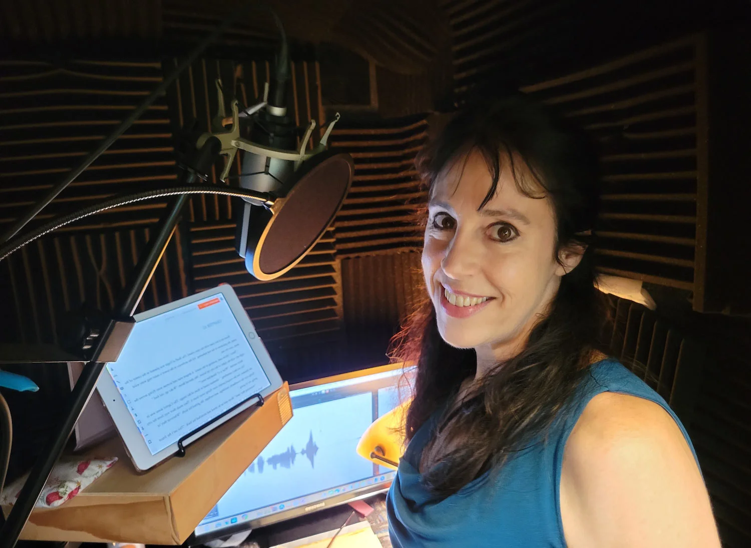 Holly looks at the camera while recording in her booth